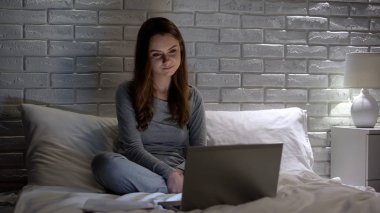 Gülümseyen kadın dizüstü bilgisayarda film izlerken, boş zaman, eğlence harcama