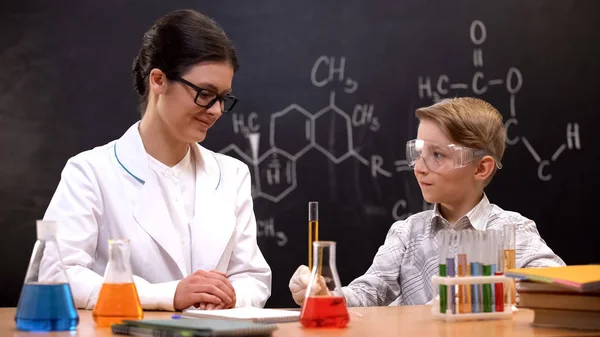 Kimya Öğretmeni Gülümseyerek Okul Çocuğu Araştırma Ders Yürüten Izlerken — Stok fotoğraf