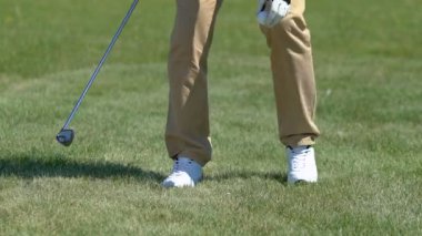 Adam golf topu kadar teeing ve sürücü atış yapmaya hazırlanıyor, oynamaya başlıyor