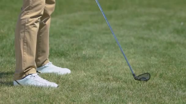 Игрок в гольф делает бросок железным клюшкой, тренируется в загородном гольф-клубе — стоковое видео