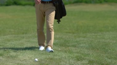 Golf çantası ile Sporcu topa geliyor, kulüp seçimi ve çekim için hazırlanıyor