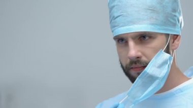 Steril maske takarak genç sağlık çalışanı, cerrahi klinik operasyon, tıp