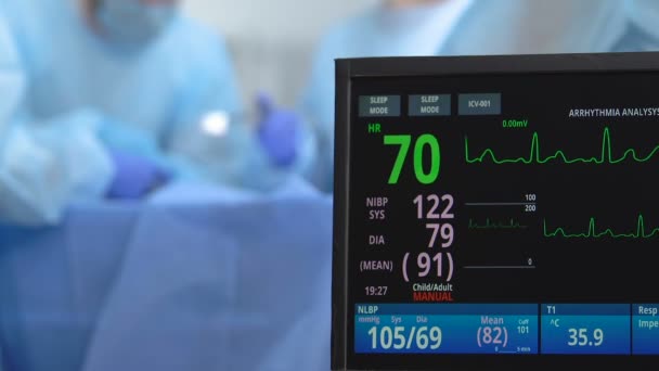 Patient heart rate an blood pressure displaying on monitor during operation — Stock Video