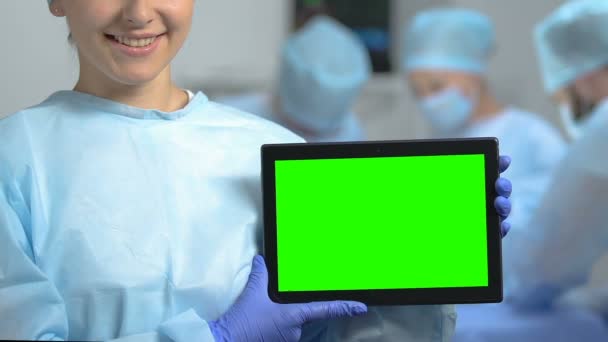 Studente di medicina sorridente che tiene tablet con schermo verde, tirocinio ospedaliero — Video Stock