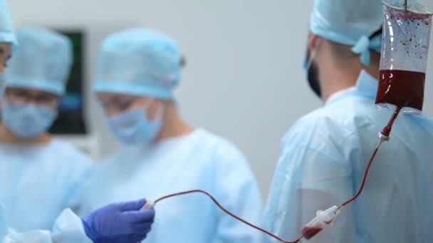 Gotejamento de transfusão de sangue na sala de cirurgia, médicos salvando o paciente vivo, saúde — Vídeo de Stock