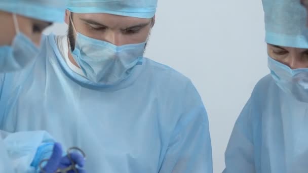 Trabajadores médicos en paciente operado uniforme, equipo profesional de la clínica, cirugía — Vídeo de stock