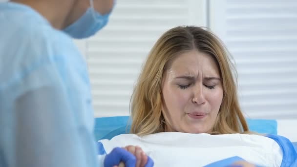 Feminino sentindo contração dolorosa segurando a mão enfermeira, parto hospitalar, cuidados — Vídeo de Stock