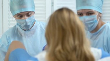 Doğum sırasında hamile kadına yardımcı kadın doktor ve işçi hemşiresi, klinik