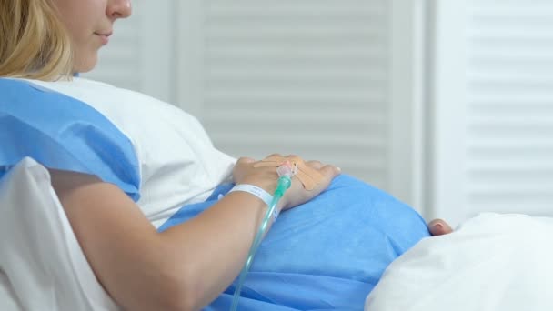 Malade femme enceinte caressant le ventre couché lit d'hôpital, problème de santé de grossesse — Video