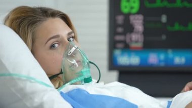 Oksijen maskesi ile depresif hasta kadın kamera görünümlü ağlıyor, hastalık ağrı sağlık