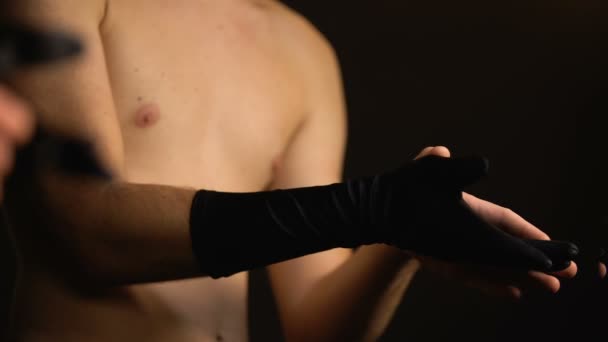 Мужчина в женской перчатке чувственно гладит свою руку, принимая трансгендерную идентичность — стоковое видео