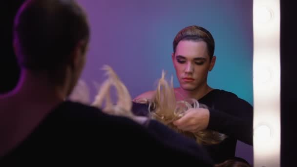 Доброзичлива подорожня дива одягає біляву перуку, готуючись до трансгендерної вечірки — стокове відео