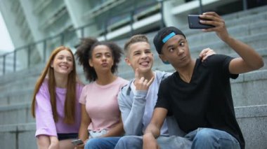 Selfie çeken, kamera önünde eğlenen çok ırklı genç arkadaşlar