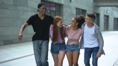 Sokakta yürüyen, gülen ve eğlenen çok ırklı gençlerden oluşan bir grup