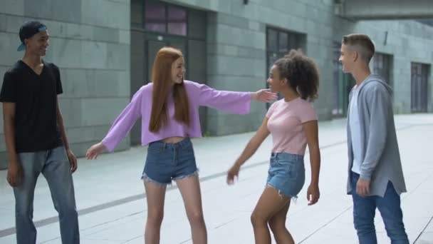 Multiethnisches Teenie-Paar, das sich umarmt und auf der Straße spaziert, gemeinsame Freizeit — Stockvideo
