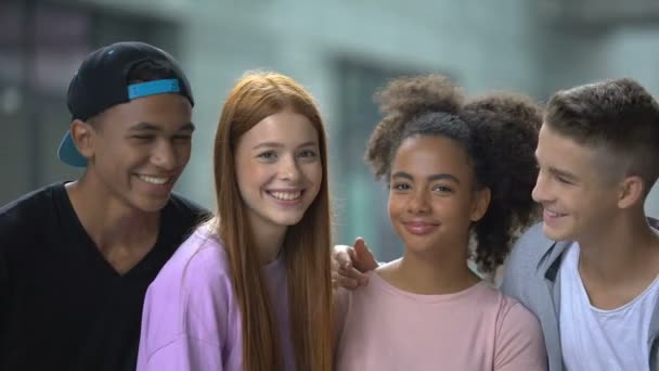 Jonge multi-etnische vrienden knuffelen en glimlachen om de camera, geheugen foto, school — Stockvideo