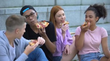 Gençlerin güler yüzlü çok ırklı grup lezzetli pizza açık havada zevk