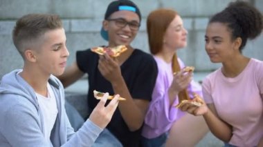 İyi ruh hali içinde gençler grubu içtenlikle pizza öğle yemeği sırasında gülüyor, dostluk
