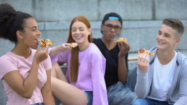 Genç çok ırklı arkadaşlar gülüyor ve iyi bir şirket, ruh hali içinde pizza zevk