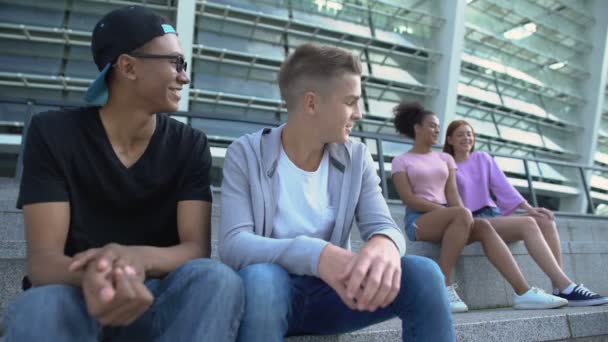Mężczyźni w szkole, patrząc z zainteresowaniem na całkiem kobiecych nastolatków, młodzież — Wideo stockowe
