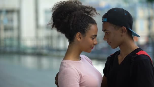 Pareja negra de adolescentes abrazándose durante la cita al aire libre, amor afecto conexión — Vídeo de stock