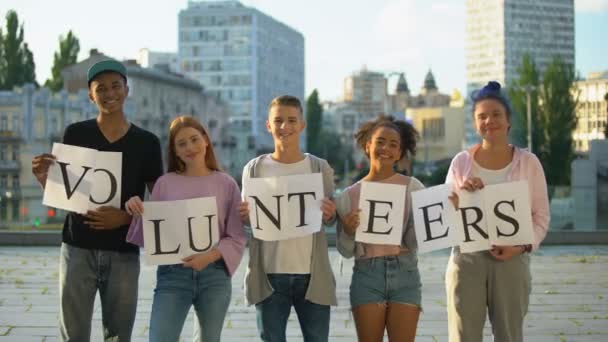 Feliz grupo de adolescentes con signo de voluntarios, proyecto social, caridad bondad — Vídeo de stock