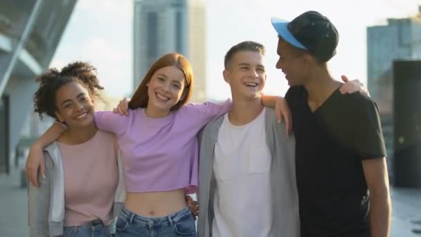 Alegre multi-racial amigos abrazando sonriente cámara, adolescencia juntos — Vídeo de stock