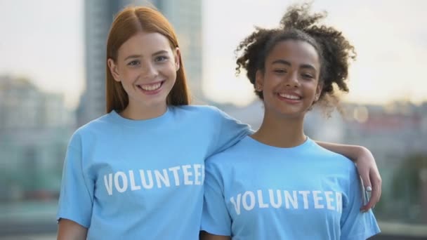 Két női önkéntesek mosolyogva a kamera, a magas iskolai jótékonysági program, önzetlenség — Stock videók