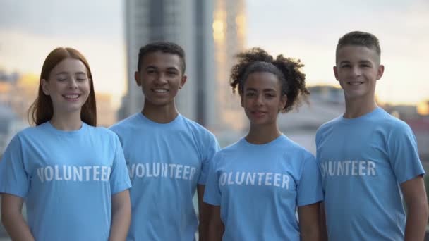 Alegre voluntarios mostrando pulgares hacia arriba sonriendo cámara, apoyo internacional — Vídeo de stock