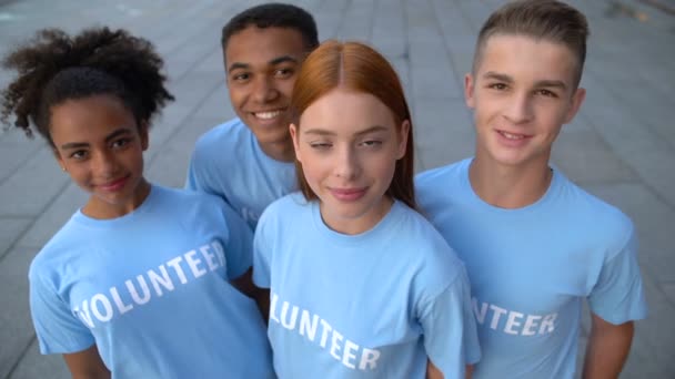 Grupo multi-étnico de jovens voluntários olhando câmera, atividade altruísta, ajuda — Vídeo de Stock