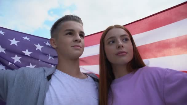 Teen couple in love touching foreheads holding american flag, young patriots — Stock Video