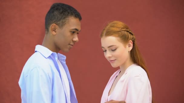 Glimlachend gemengd-race jongen teder aanraken van de schouder en kin van zijn meisje, liefde — Stockvideo