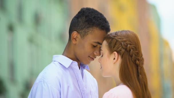 Multi-etnische tiener paar aanraken voor hoofden op zoek naar de ogen met liefde, romantiek — Stockvideo