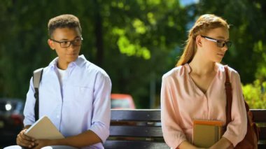 Gözlüklü ürkek öğrenciler, parkta bankta otururken, tanışmaya çalışıyor