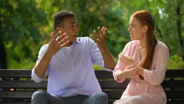 Casal multiétnico discutindo sentado no banco no parque, ciúme, mal-entendido — Vídeo de Stock