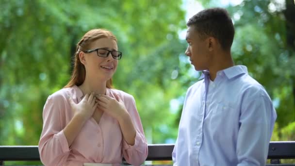 Teen girl in eyeglasses complaining her mixed-race boyfriend in park, bullying — Stock Video