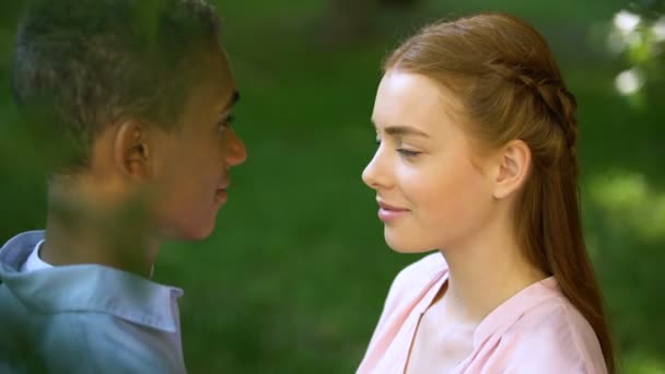 Teen διαφυλετικός ζευγάρι αγγίζοντας τα μέτωπα στο πάρκο, αξιοπιστία σχέσεις, αγάπη — Αρχείο Βίντεο