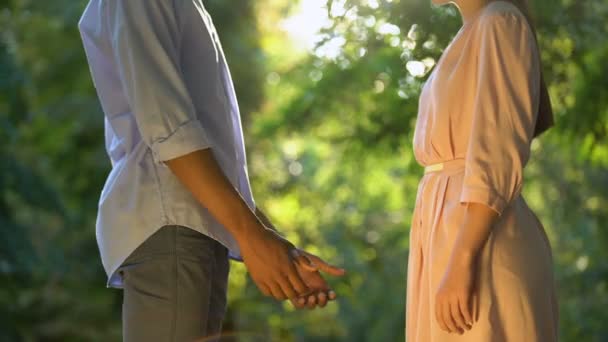 Young Afro-American boy tenderly holding girlfriends hands, first date in park — Stock Video