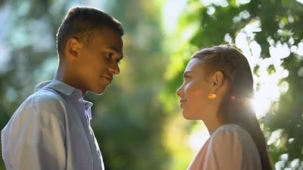 Trevlig tonårspar i kärlek leende och kramar på Sunny Park, ömhet — Stockvideo
