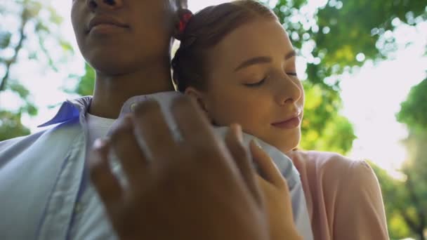 公園で若いカップルのクローズアップ、ボーイフレンドの肩に寄りかかって十代の女の子、愛 — ストック動画