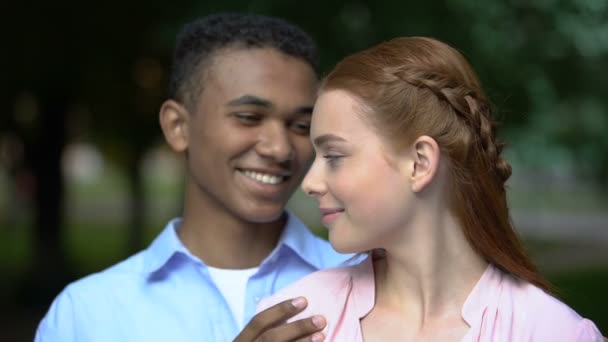 Hugging multiethnic teen couple holding paper heart, tender relationship, love — Stock Video