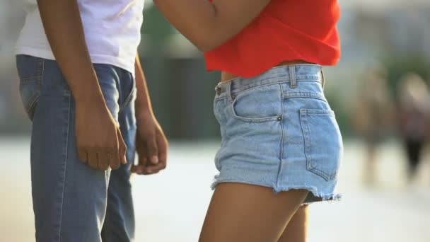 Adolescente chica en pantalones cortos abrazando tímido novio, haciendo el primer paso en el conocimiento — Vídeo de stock