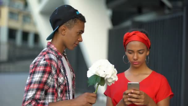 Adolescente chica sin saberlo tomar flores de niño, nación digital adicto a gadget — Vídeo de stock