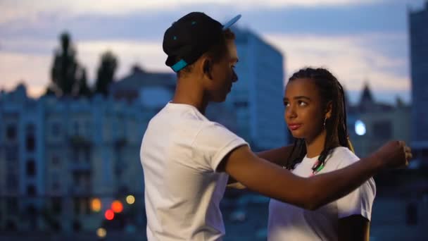 Galant genç erkek kız arkadaşı gömlek koyarak, bakım ve koruma gösteren — Stok video