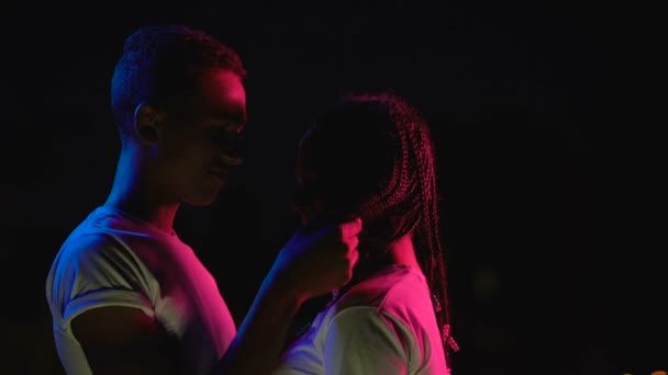 Teenie-afrikanisches Paar, das nachts lächelnd kuschelt und das gegenseitige Gefühl der Liebe genießt — Stockvideo
