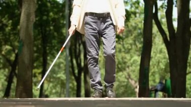 Park boyunca yürüyen beyaz bastonlu kör adam, görme engelli insanların hayatı