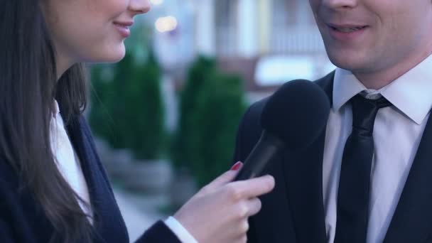 Female journalist with microphone interviewing young businessman in suit, media — Stock Video