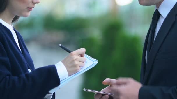 Chefe masculino dando instruções para assistente feminino fazendo anotações, planejando o cronograma — Vídeo de Stock