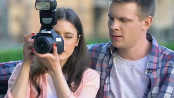 Krásná žena fotografická fotografka, mladý muž doporučovat pracovní tipy, fotografovat — Stock video