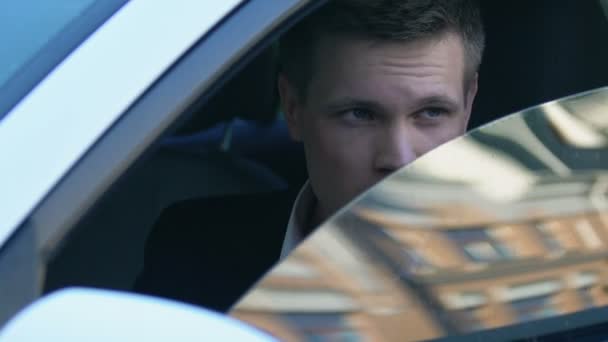 Mężczyzna detektyw patrząc przez lornetki siedzący samochód, śledztwa dziennikarza — Wideo stockowe